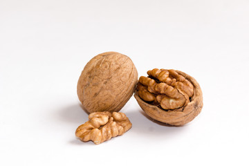 Delicious whole and broken walnuts, isolated on white background