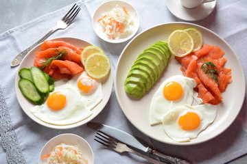 Healthy breakfast concept, fried eggs, avocado and smoked salmon, top view