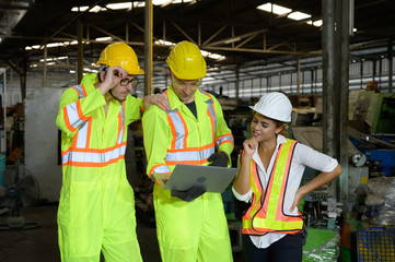 A mixed race female and two caucasian male engineer working in factory area.