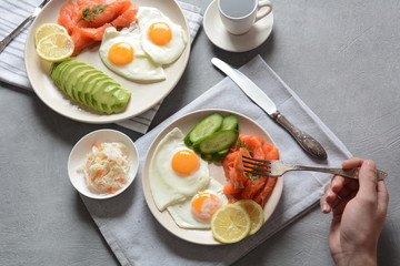 Healthy breakfast concept, fried eggs, avocado and smoked salmon, top view