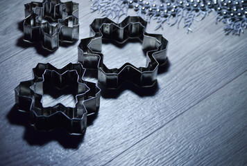 Metal molds for biscuits of various shapes on a gray background with New Year's garland