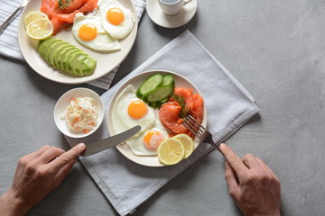 Healthy breakfast concept, fried eggs, avocado and smoked salmon, top view