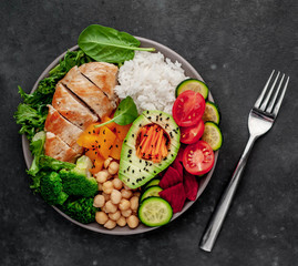 Bowl Buddha. rice, chicken breast, broccoli, pumpkin, avocado, chickpeas, carrots, cucumber, beets, a stone background