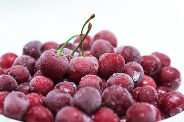 frozen fresh cherry with sprigs on a white background. an ingredient for smoothies and smoothies. ice crystals on the berry. close up.