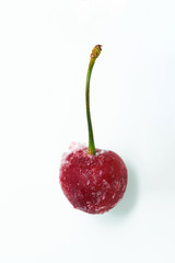 frozen cherry on a white background . ice crystals on the berry. vertical photo.