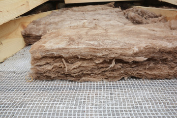 Fototapeta na wymiar Attic Roof Insulation. Close up on layers of glass wool insulation.