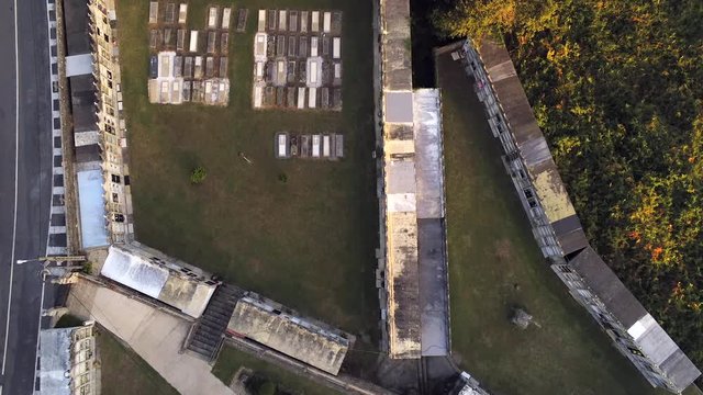 Top down aerial view of  cemtery and the bare church of ornamentation and barely, surrounded by Horreo arano, a traditional Granary.