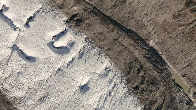 Aerial top down view of glacier in the swiss alps, slowly rotating.