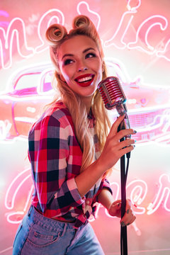 Photo of cheerful caucasian woman with microphone singing and smiling