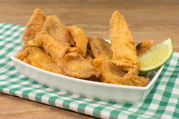 Fried Tilapia strips in platter in wood background