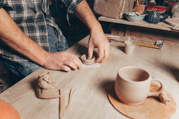 Process of creating a clay cup in pottery workshop