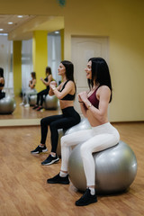 Obraz premium A group of young girls engaged in fitness on the balls. Healthy lifestyle.