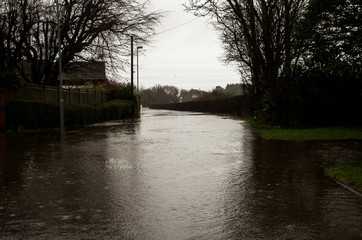Image in Thornton England of Stannah Road flooded to the curb and over with water due to Storm Ciara not allowing anyone to pass and cars becoming stuck in the flood disrupting travel plans