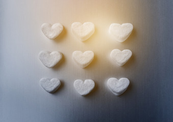 Fototapeta na wymiar white marshmallows in the shape of sugar hearts on a dark gray aluminum background