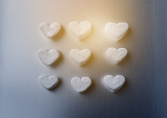 white marshmallows in the shape of sugar hearts on a dark gray aluminum background