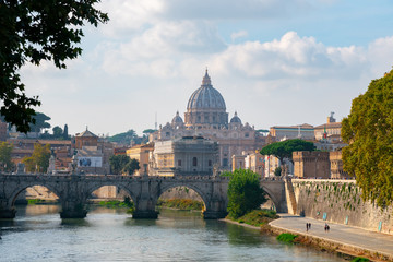 Fototapeta na wymiar St. Peter's cathedral over bridge and Tiber river water at autumn day Rome