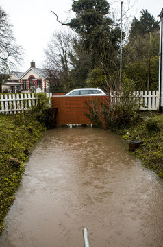 Image of Storm Ciara in england filling up the local river with water and flooding it so there is no room under the bridge for a drop more water causing issues for local houses and business'