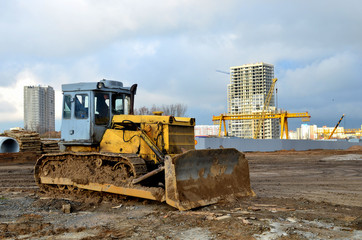 Bulldozer during of large construction jobs at building site.  Crawler tractor dozer for earth-moving. Land clearing, grading, pool excavation, utility trenching and foundation digging. © MaxSafaniuk