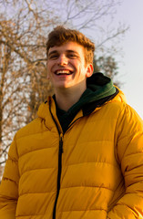 Young and handsome boy smiling in yellow jacket