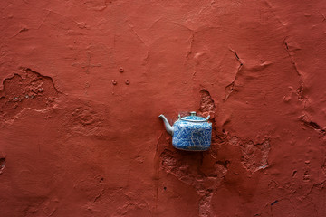 Ceramiczny czajnik umieszczony w ścianie na ulicy.