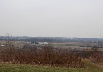 A view of the countryside on a foggy winter cloudy day.