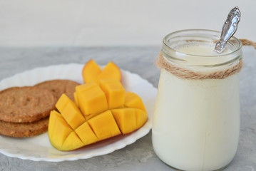 kefir / turkish drink ayran / yogurt, cereal cookies, mangoes, on a gray concrete background. Useful breakfast. Diet, weight loss, proper nutrition