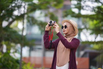 Portrait of beautiful young solo Muslim traveler exploring the city