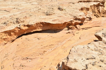 Shattered sand in the ground as a result of heavy torrential rains. Dry cracked soil of the earth...