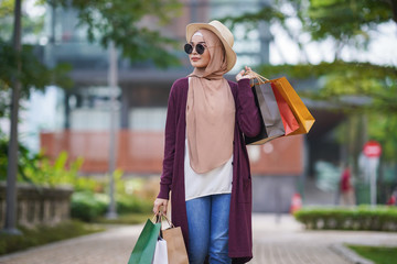 Portrait of beautiful young solo Muslim traveler exploring the city and shopping