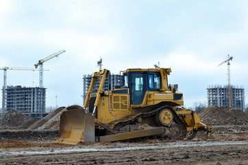 Bulldozer during of large construction jobs at building site.  Crawler tractor dozer for earth-moving. Land clearing, grading, pool excavation, utility trenching and foundation digging.