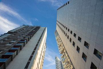 high building living apartment ordinary modern city architecture concrete exterior facade foreshortening from below on blue sky background space