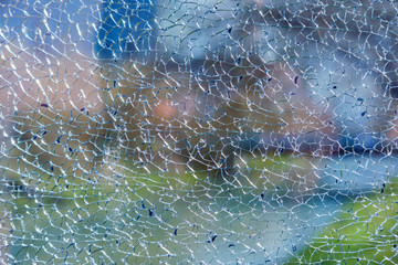 View of a blurred landscape behind the cracked glass