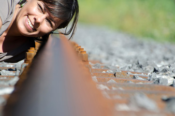 Woman Listening for a Incoming Train on the Railroad Track. - Powered by Adobe