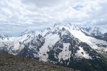 Gray snow-capped mountains of the Caucasian ridge from Dombay peak