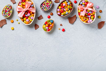 Chocolate Easter eggs and candy on concrete table, festive Easter background flat lay, copy space. Easter card with traditional Easter treats on grey table top. Sweet Easter concept