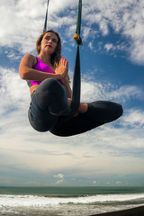 aero yoga beach workout - young attractive and athletic woman pr