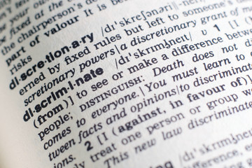 Fototapeta premium A close-up on a word Discriminate in English dictionary (selective focus)