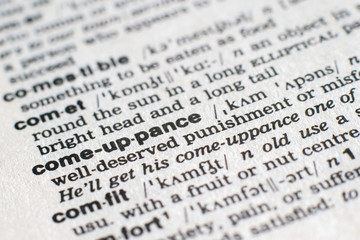 A close-up on a word Comeuppance in English dictionary (selective focus)