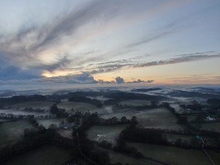An aerial view of fields and the hedges on a misty evening