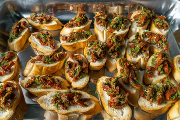 Sandwiches with sun-dried tomatoes, olives and butter.