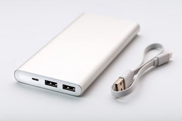 Powerbank for charging mobile devices with cable, on a white background.