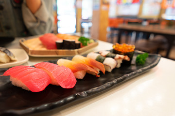Sushi and Sushi Roll Many many kinds on the table. Focus on tuna sushi