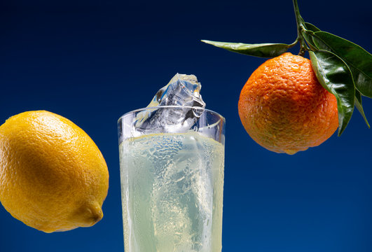 Glass with carbonated drink and pieces of ice