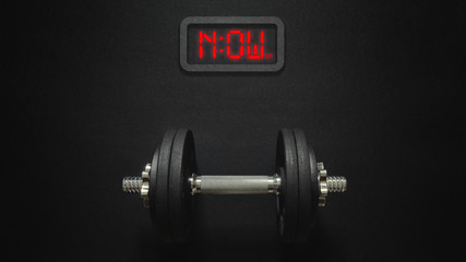 Flat lay of dumbbell with digital clock now it's the time for workout concept