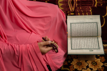 Quran - holy book of Muslims religion, Concept: open book holy prayers for god,
 Friday In the month of Ramadan  religion Islamic worshiping faith and learn koran and rosary put on wooden  boards 
