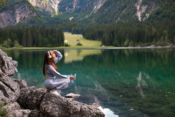 Young sports woman resting on a mountain next to the lake