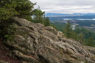 Fototapeta na wymiar Landscape of large boulder and valley below from Mount Erie in Anacortes, Washington