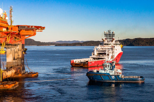 BERGEN, NORWAY - 2014 OCTOBER 16. Offshore vessel Siem Topaz and tugboat Silex under anchor handling operation alongside the semi-submersible drilling rig West Alpha