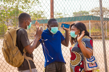 young black people wearing face masks having a conversation