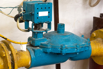 Blue flanch valve with a diameter of 50 millimeters on a yellow gas pipe in a boiler room